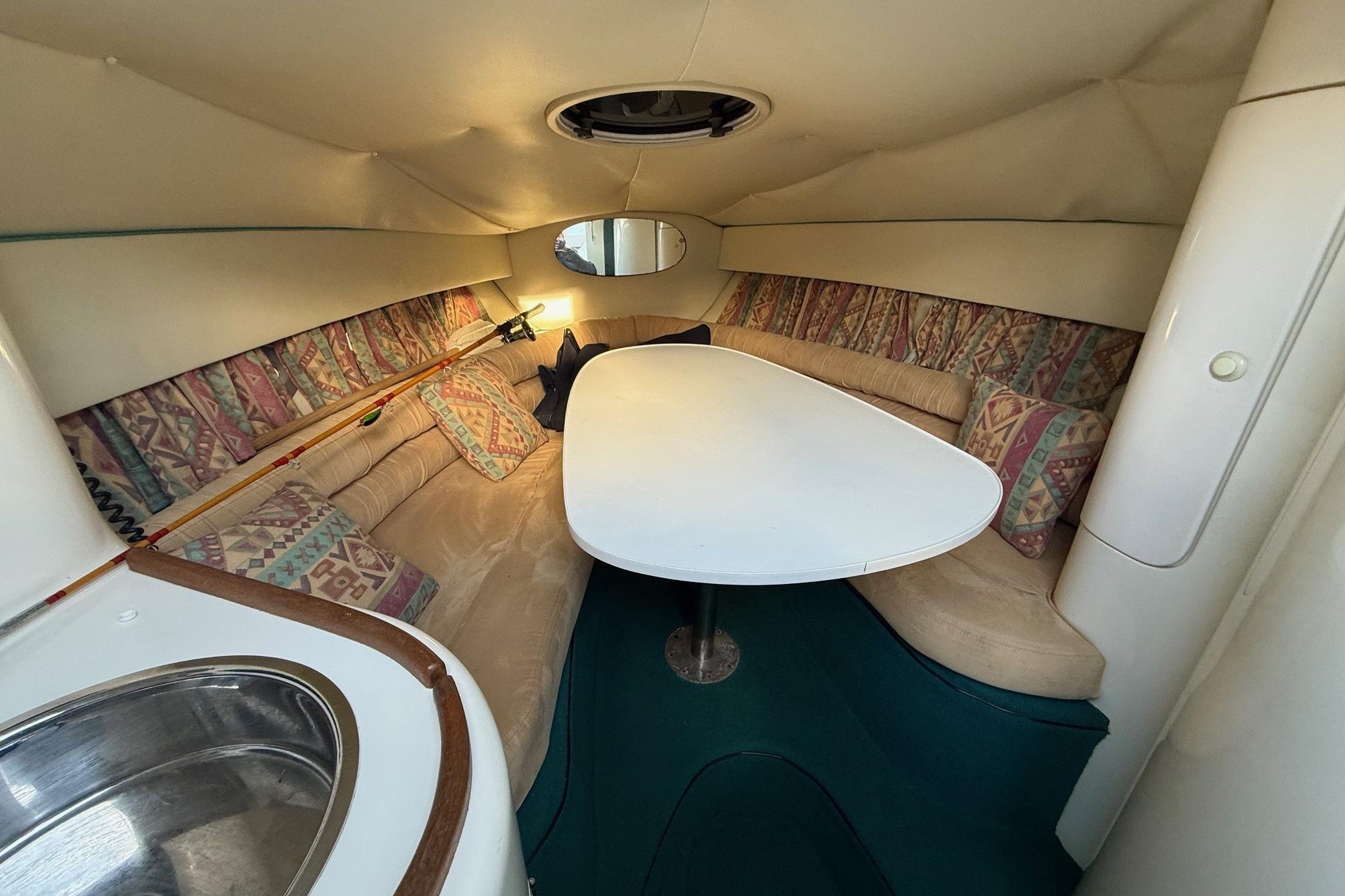 Interior of 2000 Fletcher Arrowbolt 25 boat with cozy seating and table.