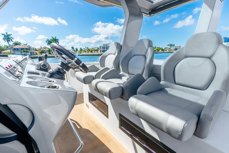  Yacht Photos Pics 2021 Pardo Yachts 43 cockpit with luxurious seating and modern controls, overlooking a scenic waterfront.