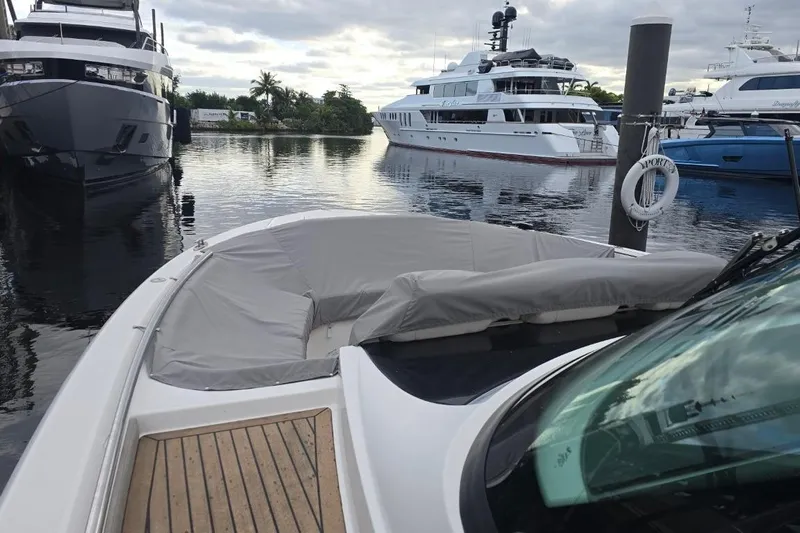  Yacht Photos Pics 2023 Tiara Yachts 48 LS docked among luxury boats in a marina setting.