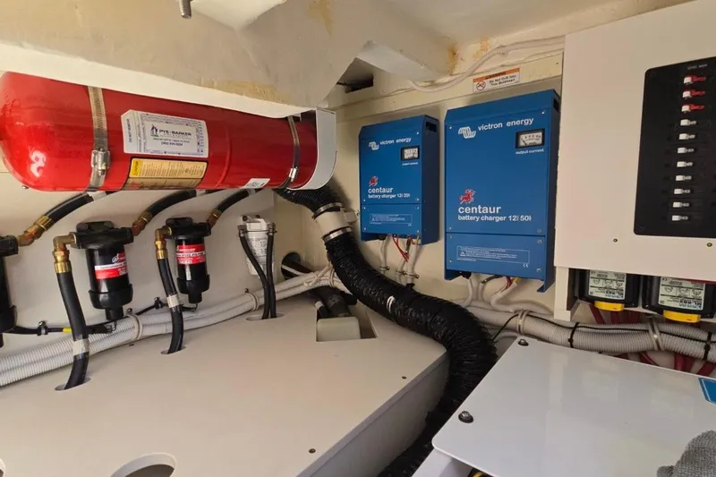  Yacht Photos Pics Engine room of 2023 Tiara Yachts 48 LS with battery chargers and fire extinguisher.