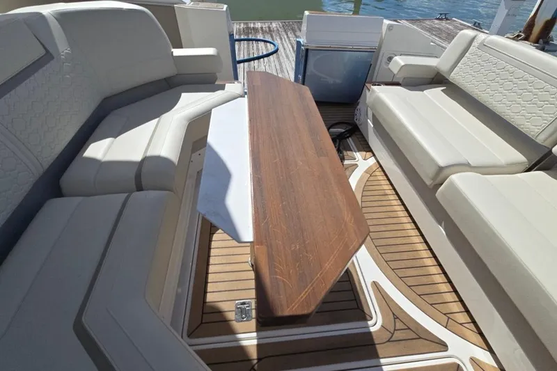  Yacht Photos Pics Luxurious seating area on 2023 Tiara Yachts 48 LS with wooden table and elegant upholstery.
