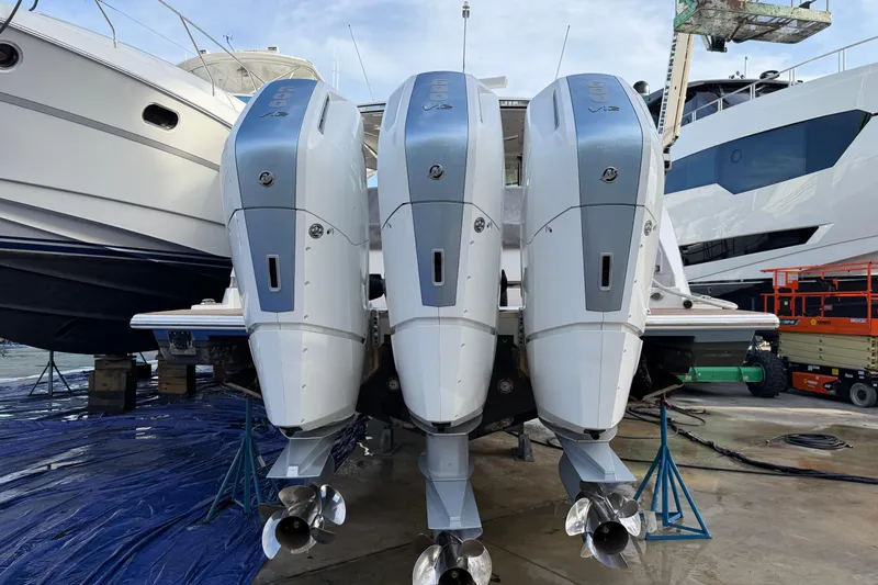  Yacht Photos Pics 2023 Tiara Yachts 48 LS with triple outboard engines in a marina setting.