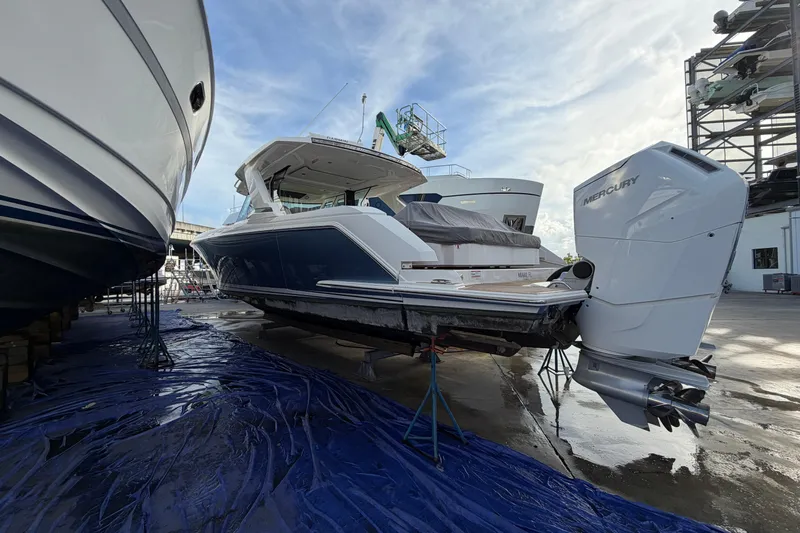  Yacht Photos Pics 2023 Tiara Yachts 48 LS in a marina, featuring Mercury outboard engines.