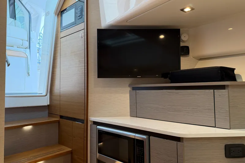  Yacht Photos Pics 2023 Tiara Yachts 48 LS interior with TV, microwave, and modern cabinetry.