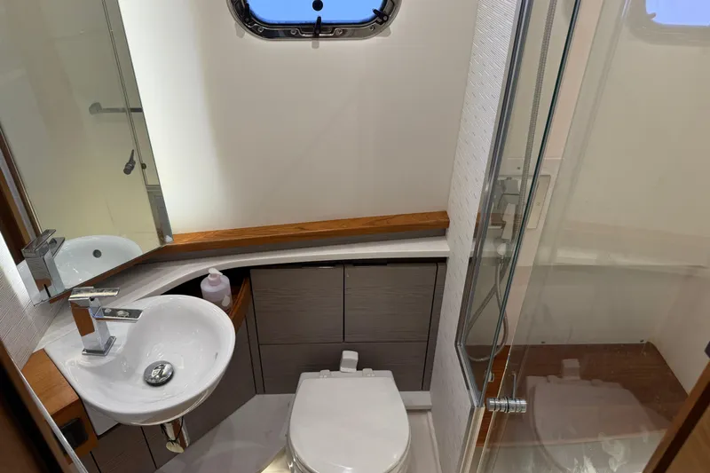  Yacht Photos Pics Luxurious bathroom in 2023 Tiara Yachts 48 LS, featuring modern sink and shower.
