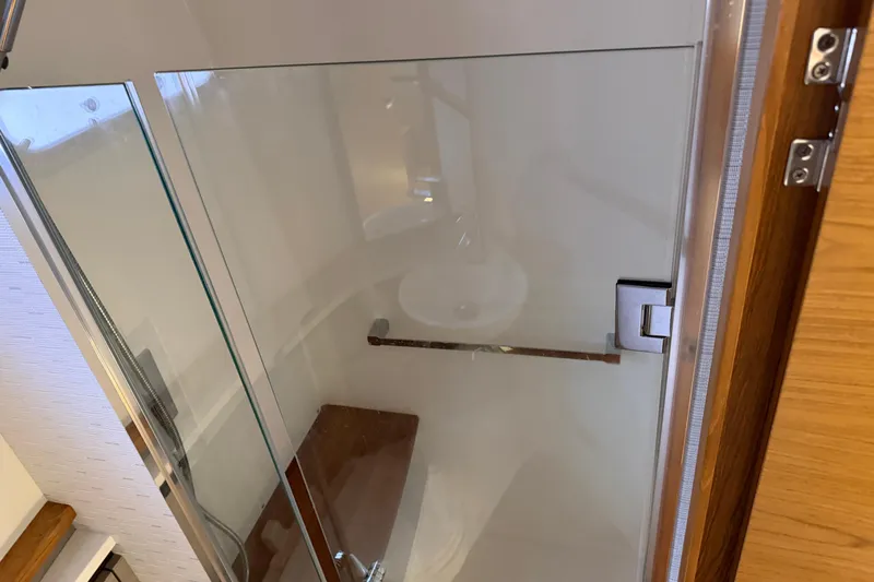  Yacht Photos Pics 2023 Tiara Yachts 48 LS bathroom with glass door and modern fixtures.