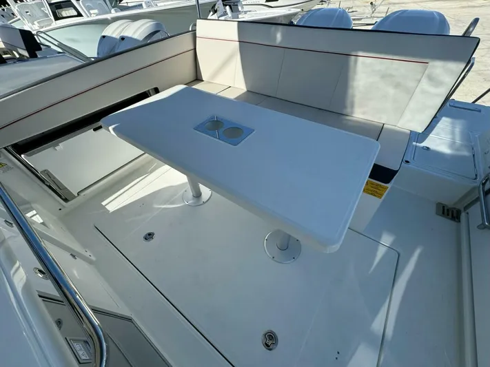  Yacht Photos Pics 2024 Jeanneau 9.0 Walk boat interior with seating and table setup.