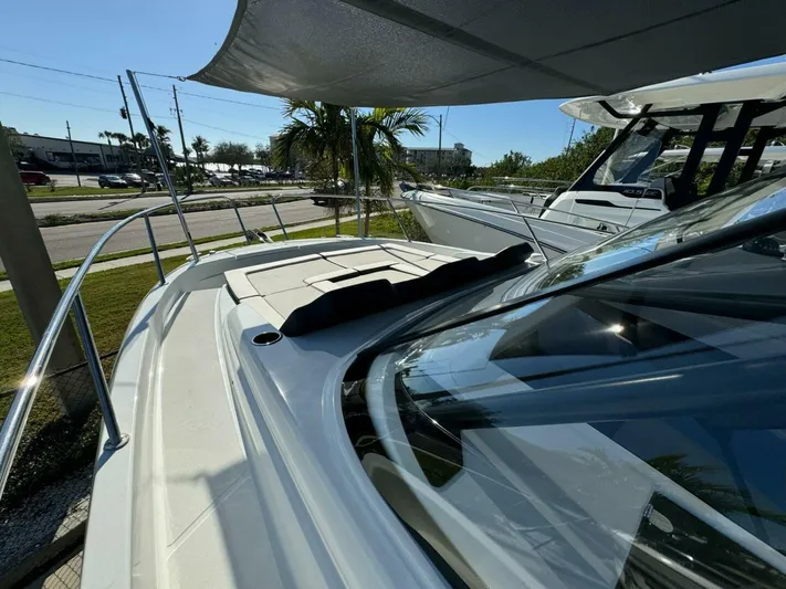  Yacht Photos Pics 2024 Jeanneau 9.0 Walk boat with sleek design and spacious deck under canopy.