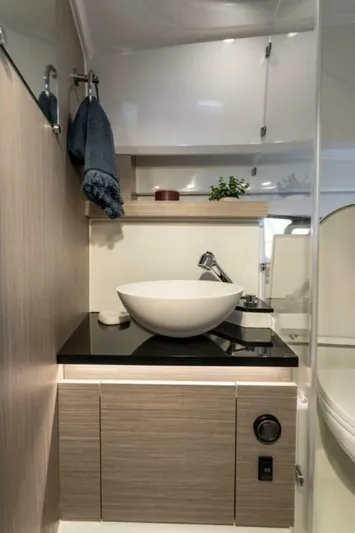  Yacht Photos Pics 2024 Jeanneau 9.0 Walk bathroom with modern sink and sleek cabinetry.