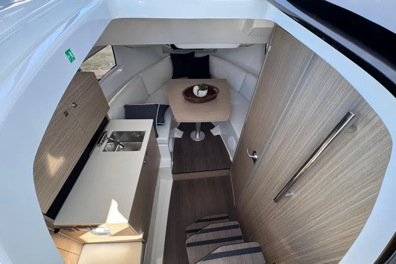  Yacht Photos Pics 2024 Jeanneau Leader 9.0 WA Series 2 cabin interior with kitchenette and seating area.