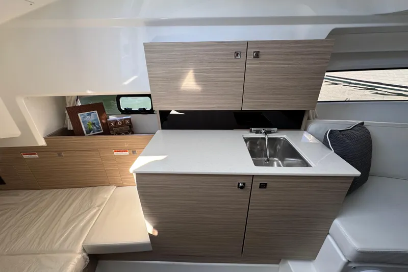  Yacht Photos Pics 2024 Jeanneau Leader 9.0 WA Series 2 interior with modern kitchenette and seating area.