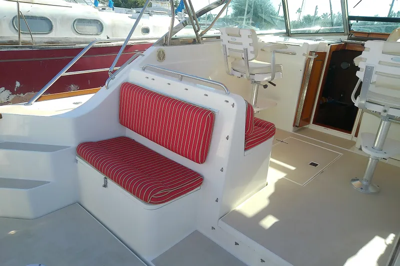 Kathrine E. Yacht Photos Pics 2002 Sabreline 36 Express boat interior with red-striped seating and helm chairs.