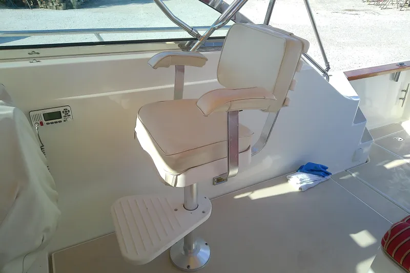 Kathrine E. Yacht Photos Pics Captain's chair on 2002 Sabreline 36 Express boat, featuring white upholstery and footrest.
