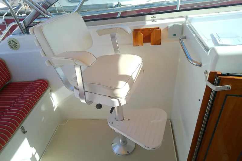 Kathrine E. Yacht Photos Pics Captain's chair on 2002 Sabreline 36 Express boat, featuring white upholstery and footrest.
