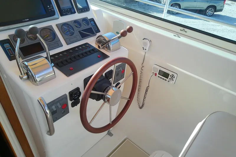 Kathrine E. Yacht Photos Pics Control panel of a 2002 Sabreline 36 Express boat with steering wheel and gauges.