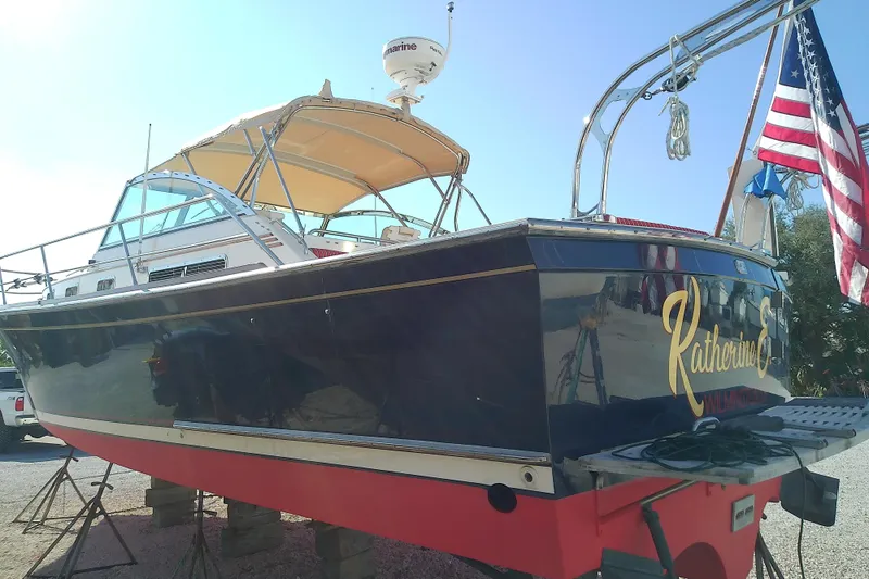 Kathrine E. Yacht Photos Pics 2002 Sabreline 36 Express boat with American flag, docked on land.