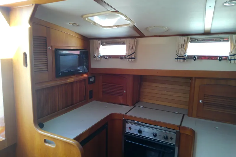 Kathrine E. Yacht Photos Pics Interior of 2002 Sabreline 36 Express yacht kitchen with wood cabinetry and appliances.