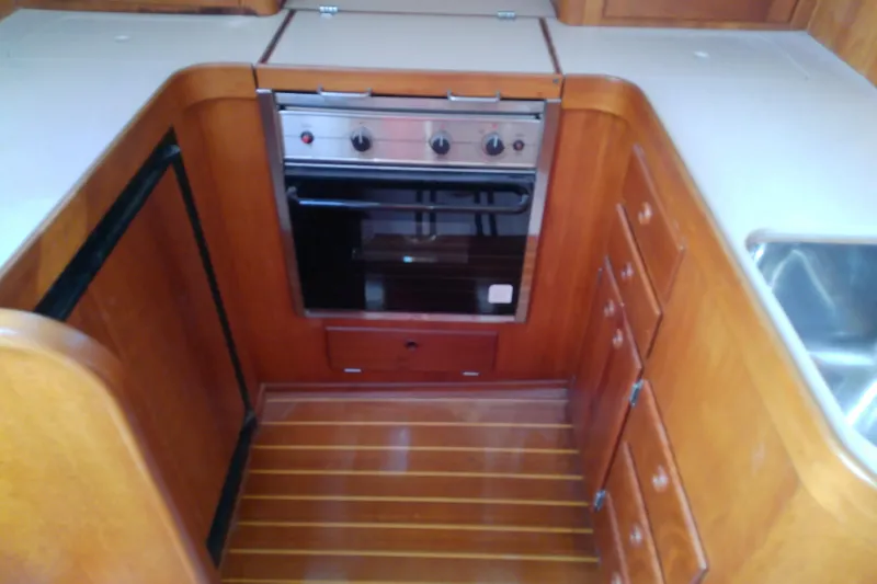 Kathrine E. Yacht Photos Pics 2002 Sabreline 36 Express yacht kitchen with wooden cabinetry and built-in oven.