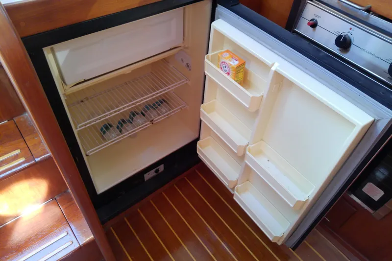 Kathrine E. Yacht Photos Pics Open refrigerator in 2002 Sabreline 36 Express boat galley, showing shelves and baking soda box.