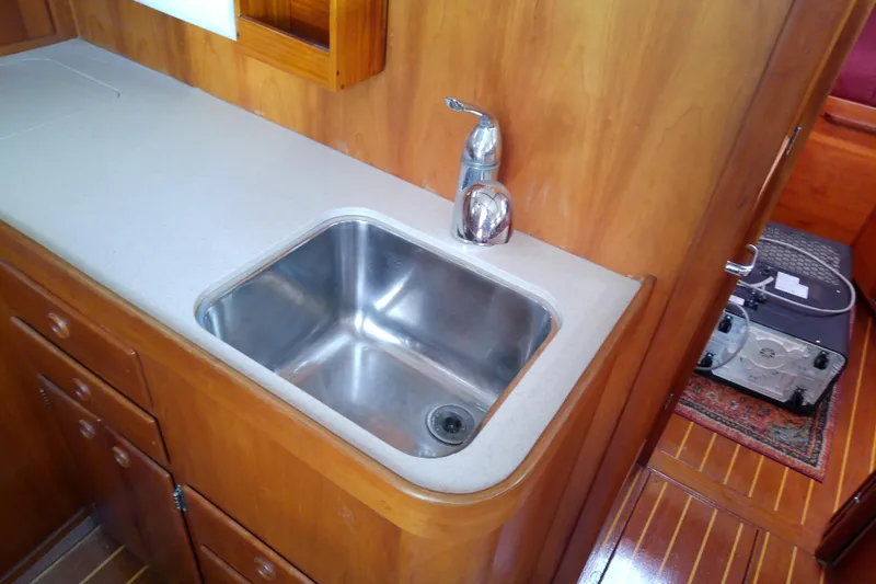 Kathrine E. Yacht Photos Pics 2002 Sabreline 36 Express yacht interior with wooden cabinetry and stainless steel sink.