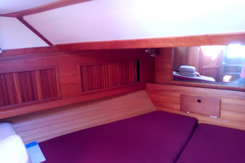 Kathrine E. Yacht Photos Pics 2002 Sabreline 36 Express cabin interior with wooden paneling and maroon bedding.