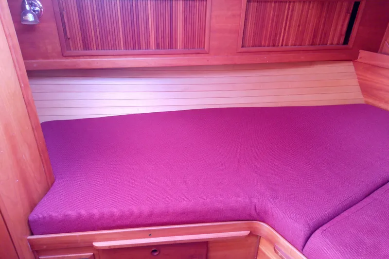 Kathrine E. Yacht Photos Pics 2002 Sabreline 36 Express cabin with purple bedding and wooden interior.