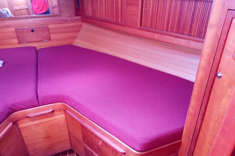 Kathrine E. Yacht Photos Pics Interior cabin of 2002 Sabreline 36 Express with wooden finish and maroon upholstery.