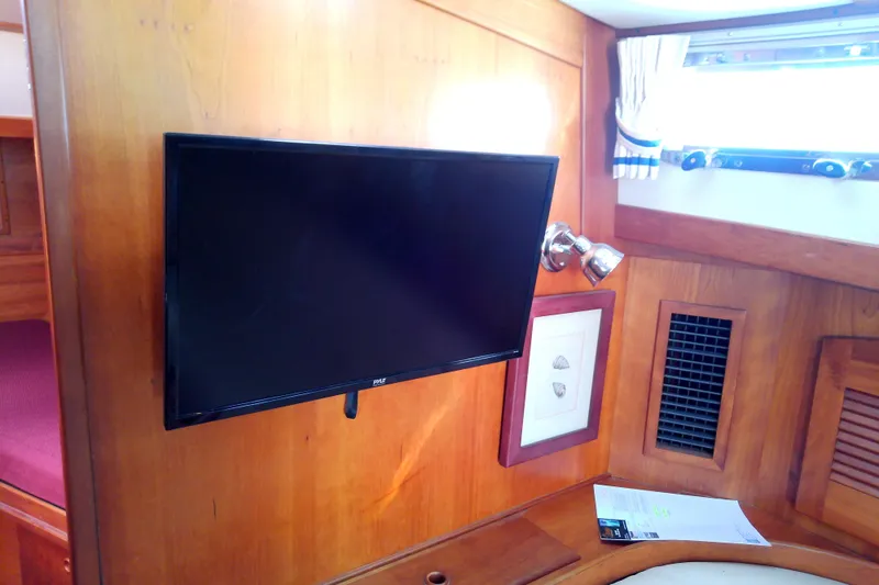 Kathrine E. Yacht Photos Pics Interior of 2002 Sabreline 36 Express with mounted TV and wooden paneling.