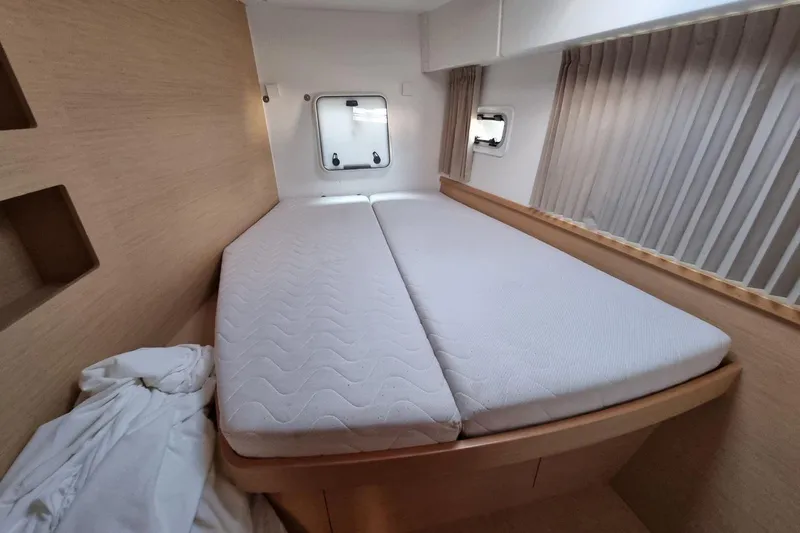  Yacht Photos Pics Interior cabin of 2017 Lagoon 42 catamaran with double bed and porthole windows.