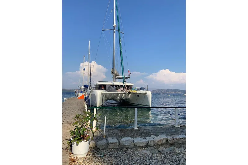  Yacht Photos Pics 2017 Lagoon 42 catamaran docked by the sea under a clear blue sky.