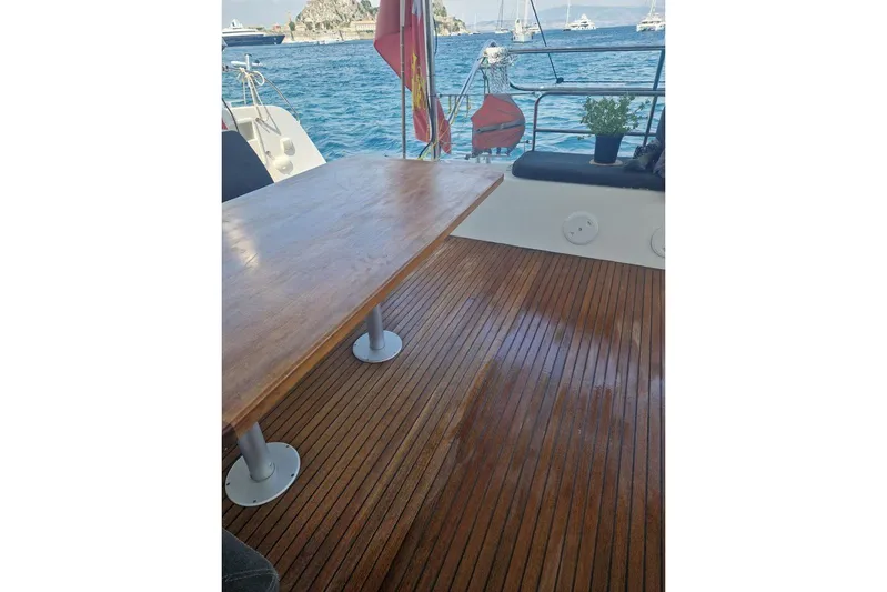  Yacht Photos Pics Wooden deck of a 2017 Lagoon 42 catamaran with a table, overlooking the sea.