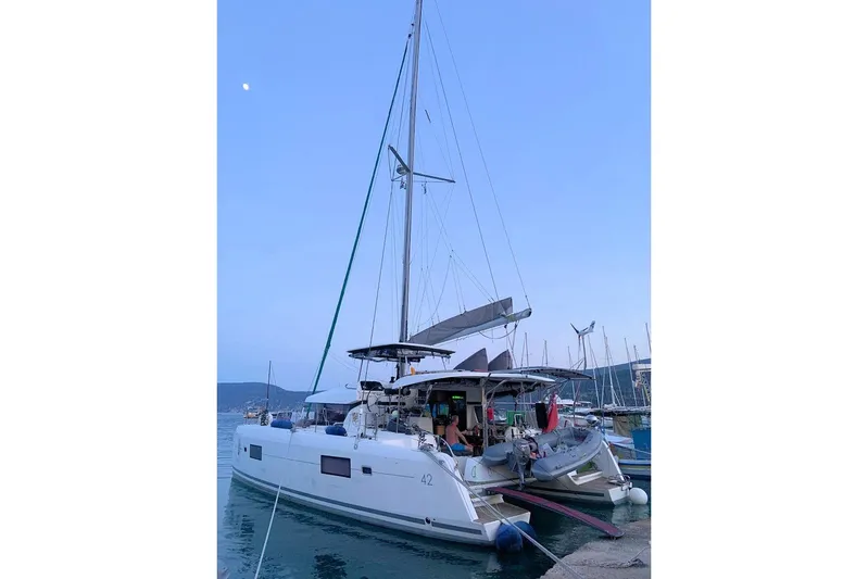  Yacht Photos Pics 2017 Lagoon 42 catamaran docked at marina during twilight, with visible sails and equipment.