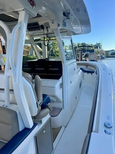 Mambo #5 Yacht Photos Pics 2017 Scout LXF 350 boat interior with seating and control panel, docked by a scenic waterfront.