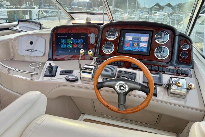  Yacht Photos Pics 2004 Sea Ray 420 Sundancer helm with modern navigation displays and wooden steering wheel.