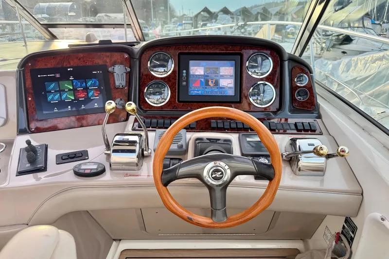  Yacht Photos Pics 2004 Sea Ray 420 Sundancer helm with wood steering wheel and modern navigation displays.