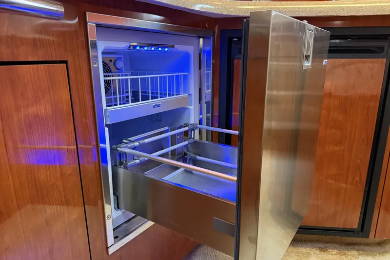  Yacht Photos Pics Open stainless steel refrigerator on 2004 Sea Ray 420 Sundancer yacht, featuring blue interior lighting.