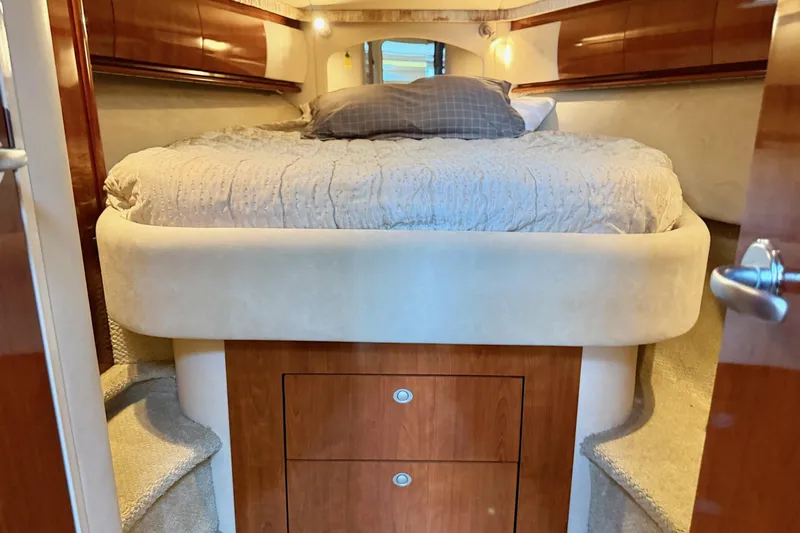  Yacht Photos Pics Luxurious cabin interior of 2004 Sea Ray 420 Sundancer yacht with cozy bed and wooden accents.