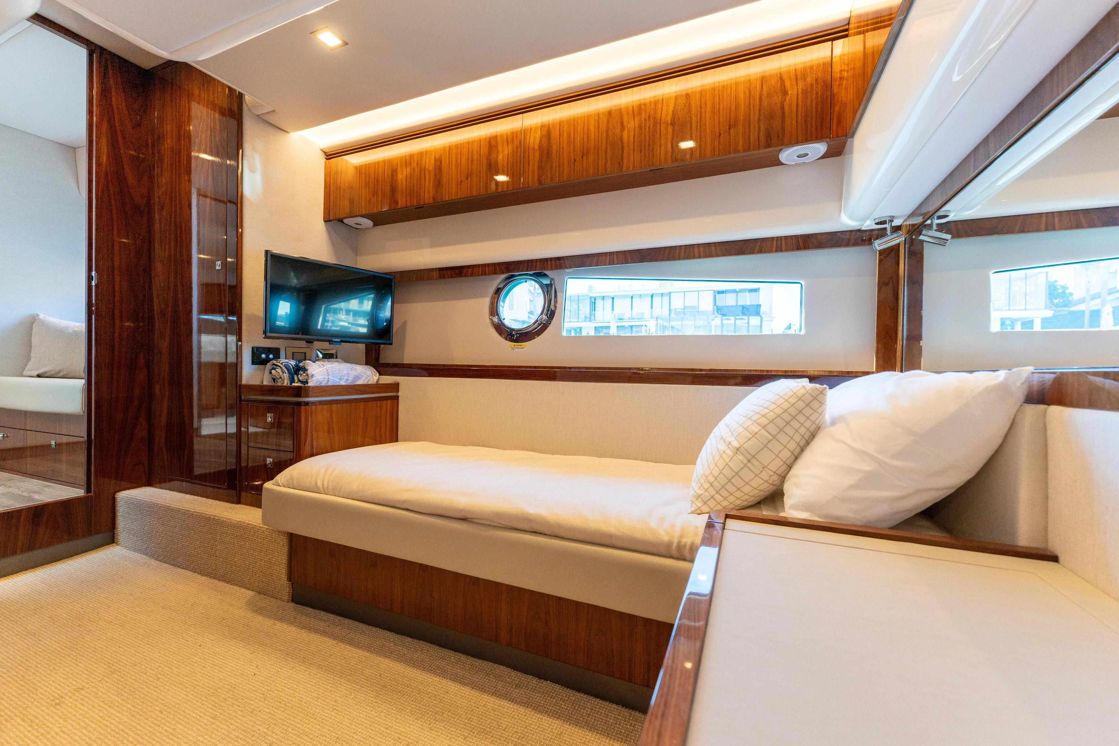 Ventures64 Yacht Photos Pics Luxurious interior of 2022 Riviera 4800 Sport Yacht with wood accents and cozy seating.