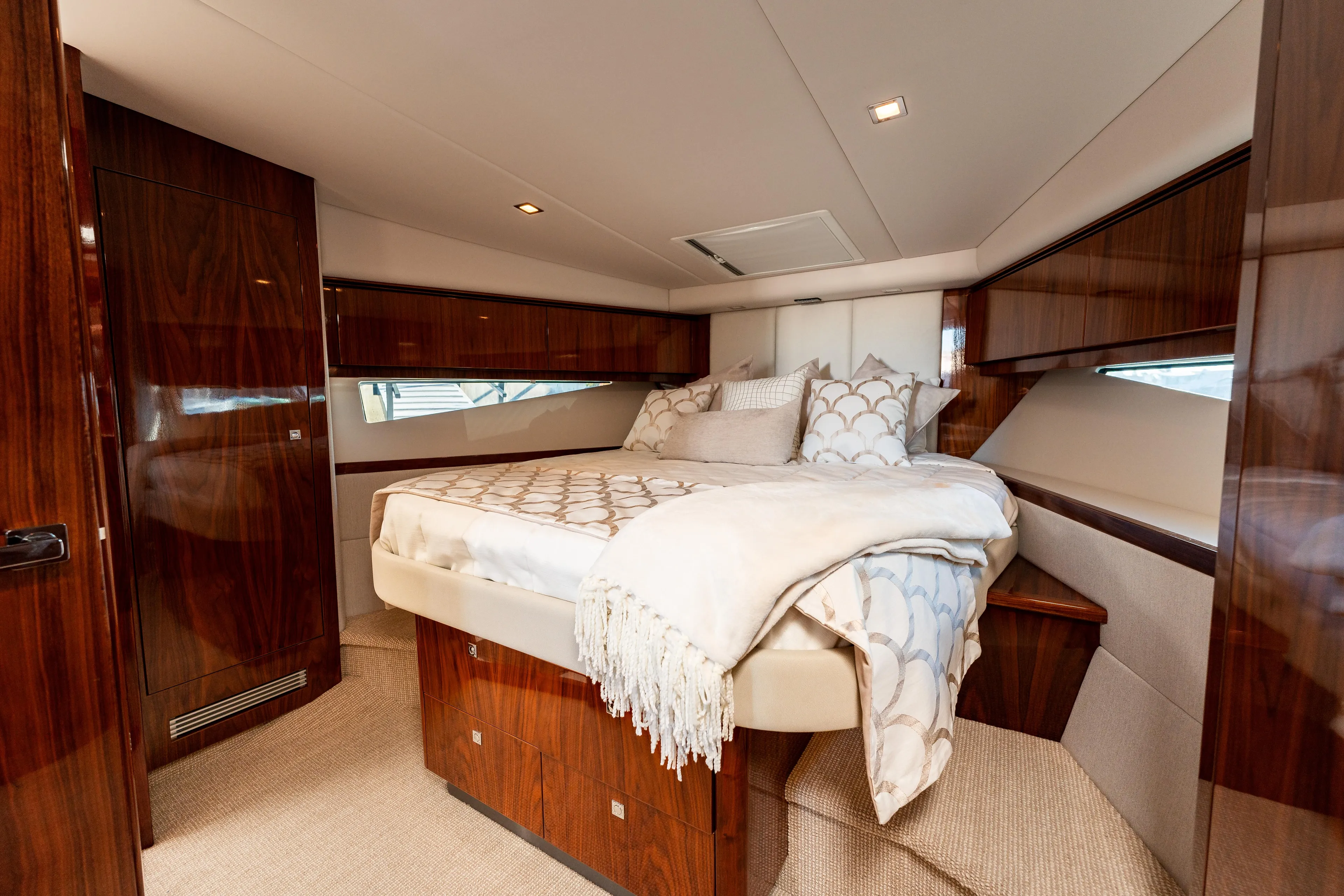 Ventures64 Yacht Photos Pics Luxurious bedroom interior of 2022 Riviera 4800 Sport Yacht with elegant wood finishes.