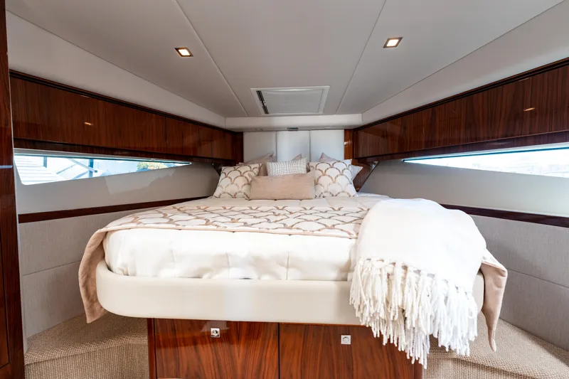 Ventures64 Yacht Photos Pics Luxurious bedroom interior of 2022 Riviera 4800 Sport Yacht with elegant bedding.