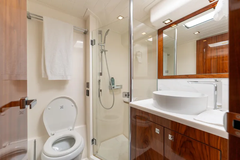 Ventures64 Yacht Photos Pics Luxurious bathroom in 2022 Riviera 4800 Sport Yacht with modern fixtures and wood accents.