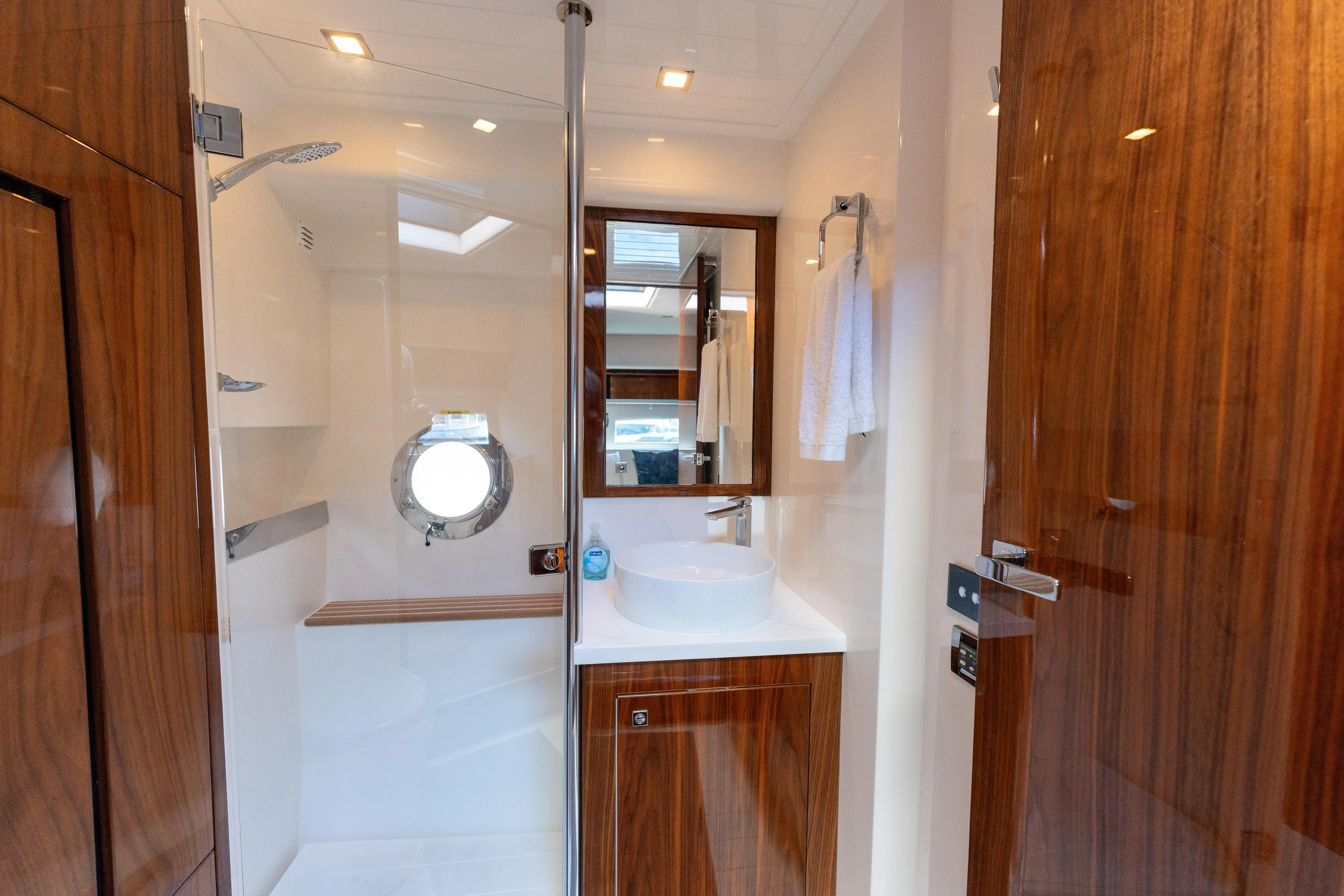 Ventures64 Yacht Photos Pics Luxurious bathroom in 2022 Riviera 4800 Sport Yacht with wood accents and modern fixtures.