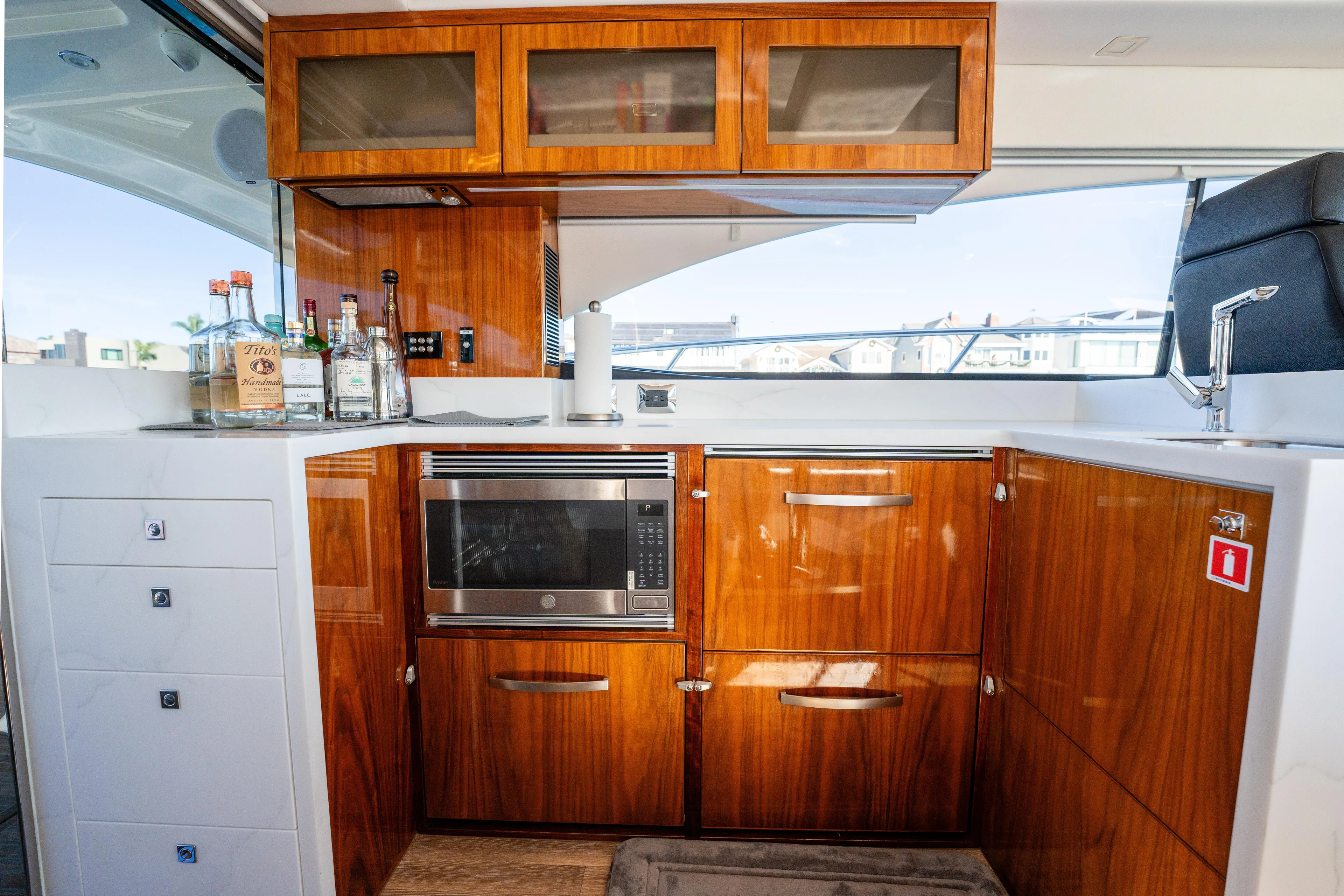 Ventures64 Yacht Photos Pics Luxurious 2022 Riviera 4800 Sport Yacht kitchen with wood cabinetry and modern appliances.