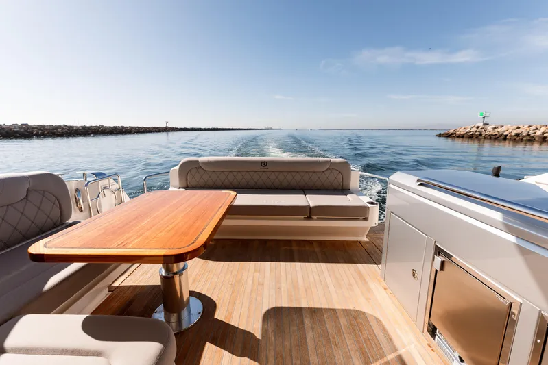 Ventures64 Yacht Photos Pics Riviera 4800 Sport Yacht 2022, luxurious deck with seating and table, ocean view.