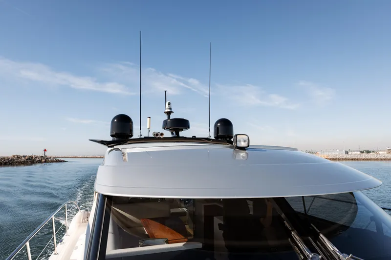 Ventures64 Yacht Photos Pics 2022 Riviera 4800 Sport Yacht cruising on open water under clear skies.