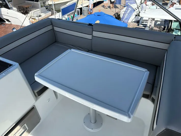  Yacht Photos Pics Flybridge seating area on 2025 Jeanneau 1295 FLY yacht with table and cushions.