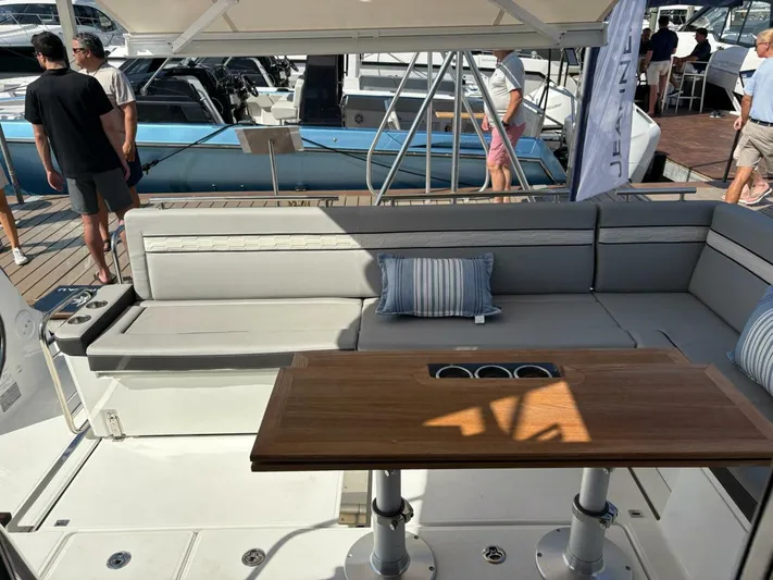  Yacht Photos Pics Luxurious Jeanneau 1295 FLY 2025 yacht interior with elegant seating and wooden table.