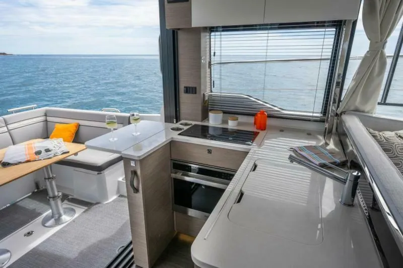  Yacht Photos Pics Interior of 2025 Jeanneau 1295 FLY yacht with modern kitchen and ocean view.