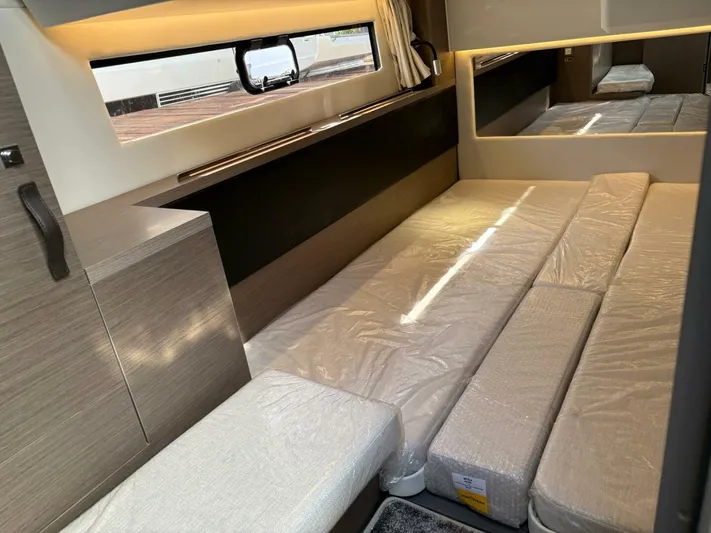  Yacht Photos Pics Interior cabin of 2025 Jeanneau 1295 FLY yacht with modern bedding and window view.