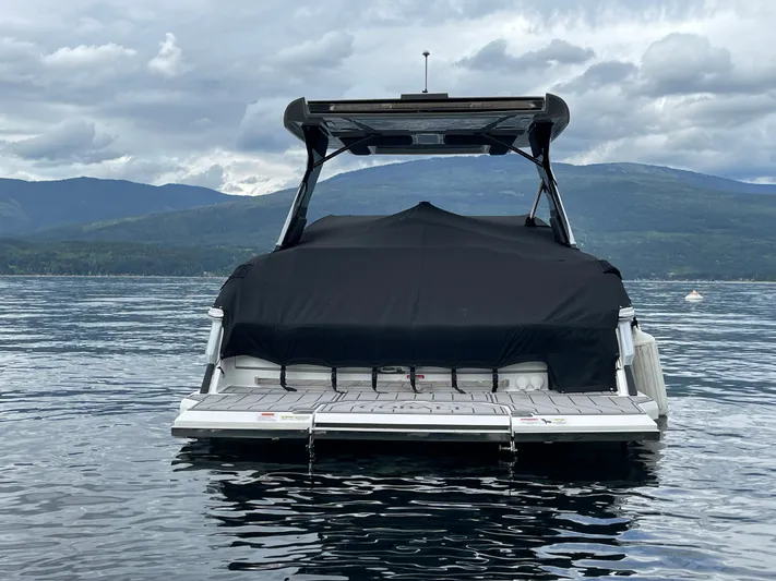  Yacht Photos Pics 2020 Cobalt A29 boat with cover on a serene lake, mountains in the background.